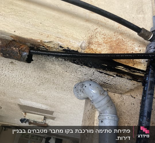 צינור מתכת חלוד עם נזילה ושפיכת נוזל שחור